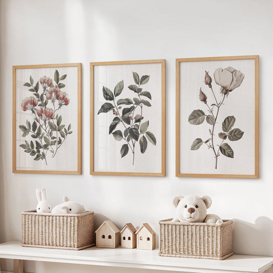 Vintage botanical flower prints, a three-piece artwork set, hang over toy storage in the kids room with natural oak frames, warming the nook with soft greens.