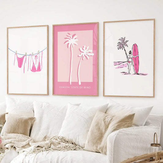 Set of 3 pink coastal wall art prints with bikini, palm, and surf design. Thinwood frames for living room.