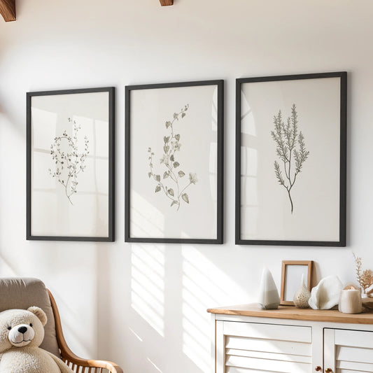 Herbarium wall art, three-piece set, in slim black frames, styled for a kids room and hanging above the chest of drawers for a soft, rustic touch.