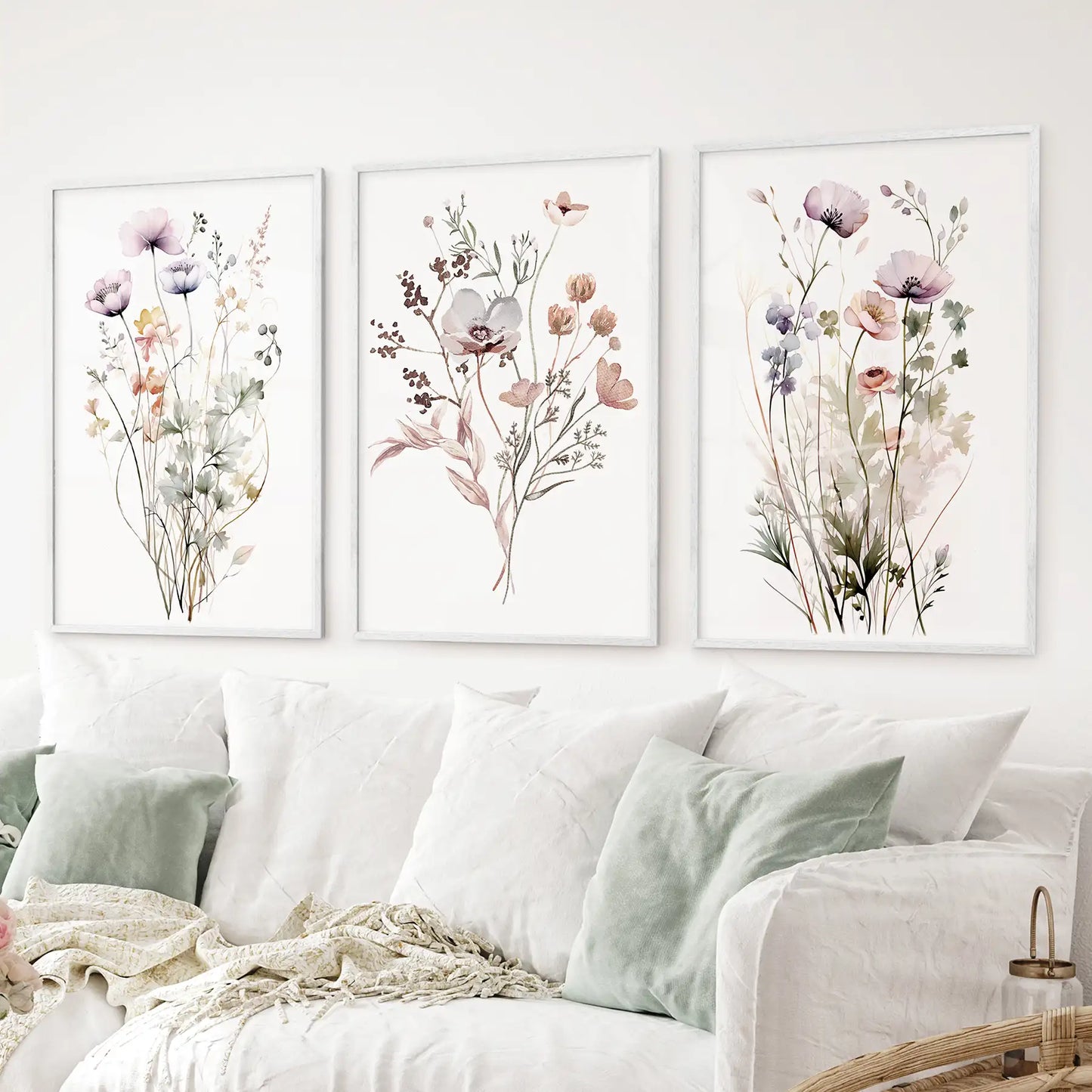 Elegant 3 piece wildflower art set in pastel tones watercolor poppies and anemones. White frames above the sofa.