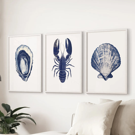 Lobster and oyster wall art, a 3-piece poster set, hangs above the couch in the living room with white frames, bringing crisp seaside character.