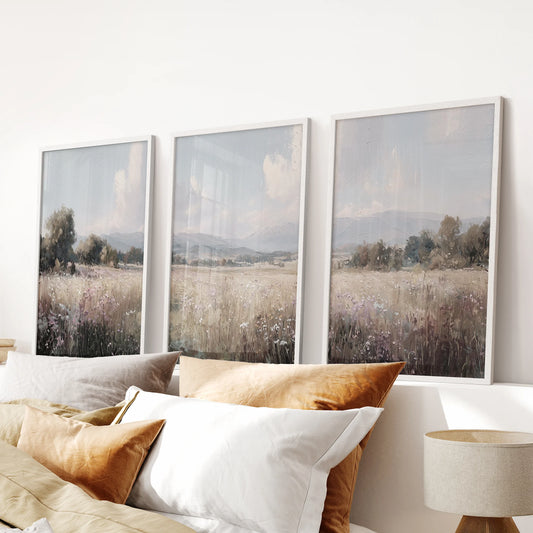 Country cottage and trees poster set of three in white frames, designed as wall art above the headboard to soften a cozy bedroom.