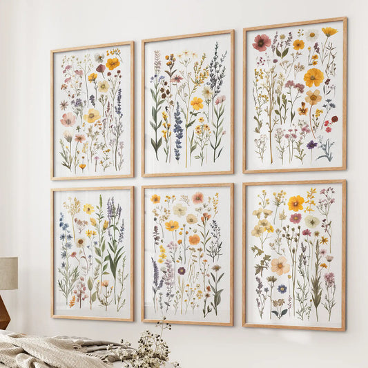 Gallery wall of delicate pressed flower minimalist illustrations.Herbarium style prints. Thinwood frames over the bed.