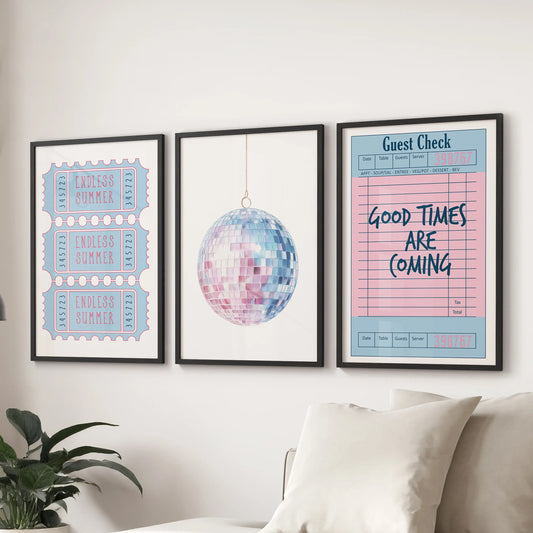 A three-piece framed art set sits behind the sofa, blending beach ticket, disco ball, and guest check imagery for a coastal pop in the lounge.