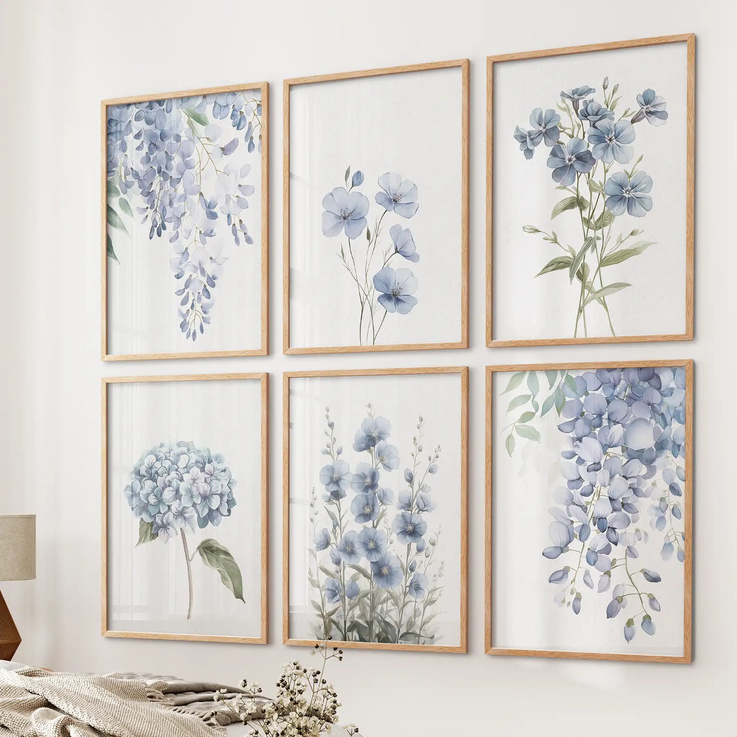 Set of 6 blue watercolor floral art prints with wisteria, flax, and hydrangea. Botanical modern wall decor. Thinwood frames over the bed.