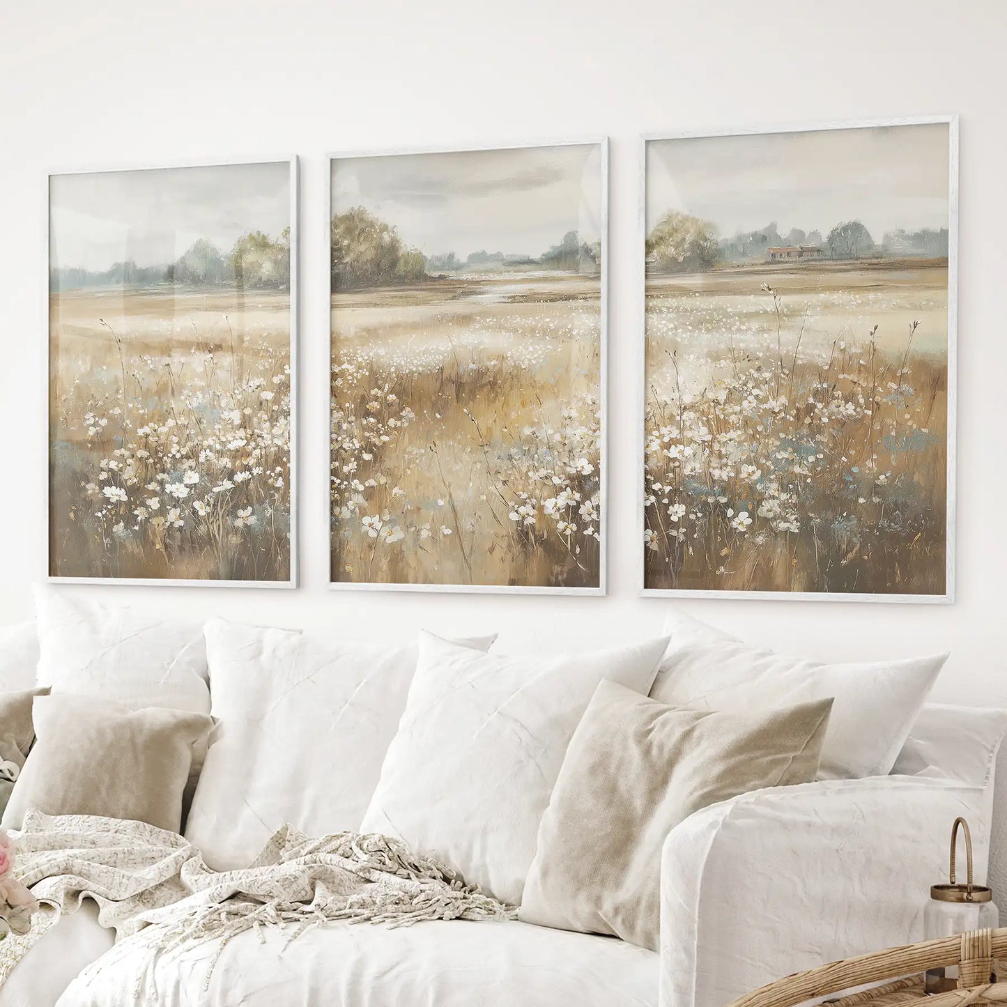 Rustic field wall art featuring a golden meadow with white flowers. 3 pieces vintage wall art. White frames above the sofa.