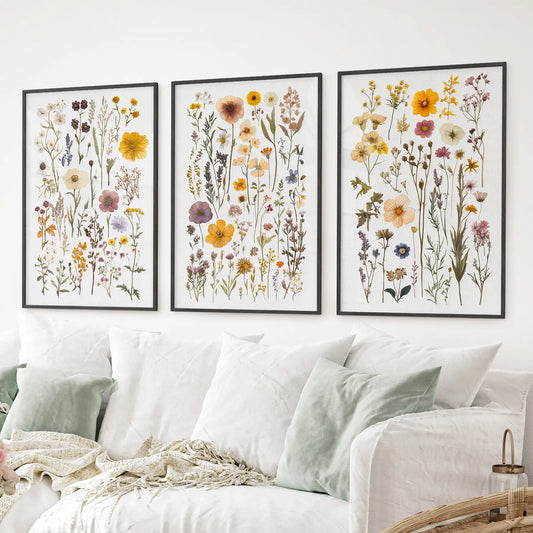 Colorful botanical poster set with yellow, purple, and pink florals. Black frames over the couch.