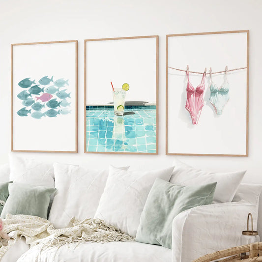 3 piece summer wall art set with watercolor fish, poolside lemonade, and swimsuits. Thinwood frames over the couch.