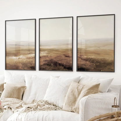 Country painting art print. Abstract landscape wall art featuring soft beige fields and hazy horizons. Black frames above the sofa.