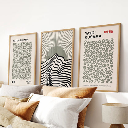 Exhibition-style modern prints, a 3-piece set positioned above the headboard in warm oak frames, lending quiet structure and balance to a serene bedroom.