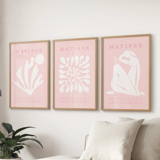 Blush abstract prints, a three-print wall set, sit in oak wood frames above the sofa to add calm color to the family room.