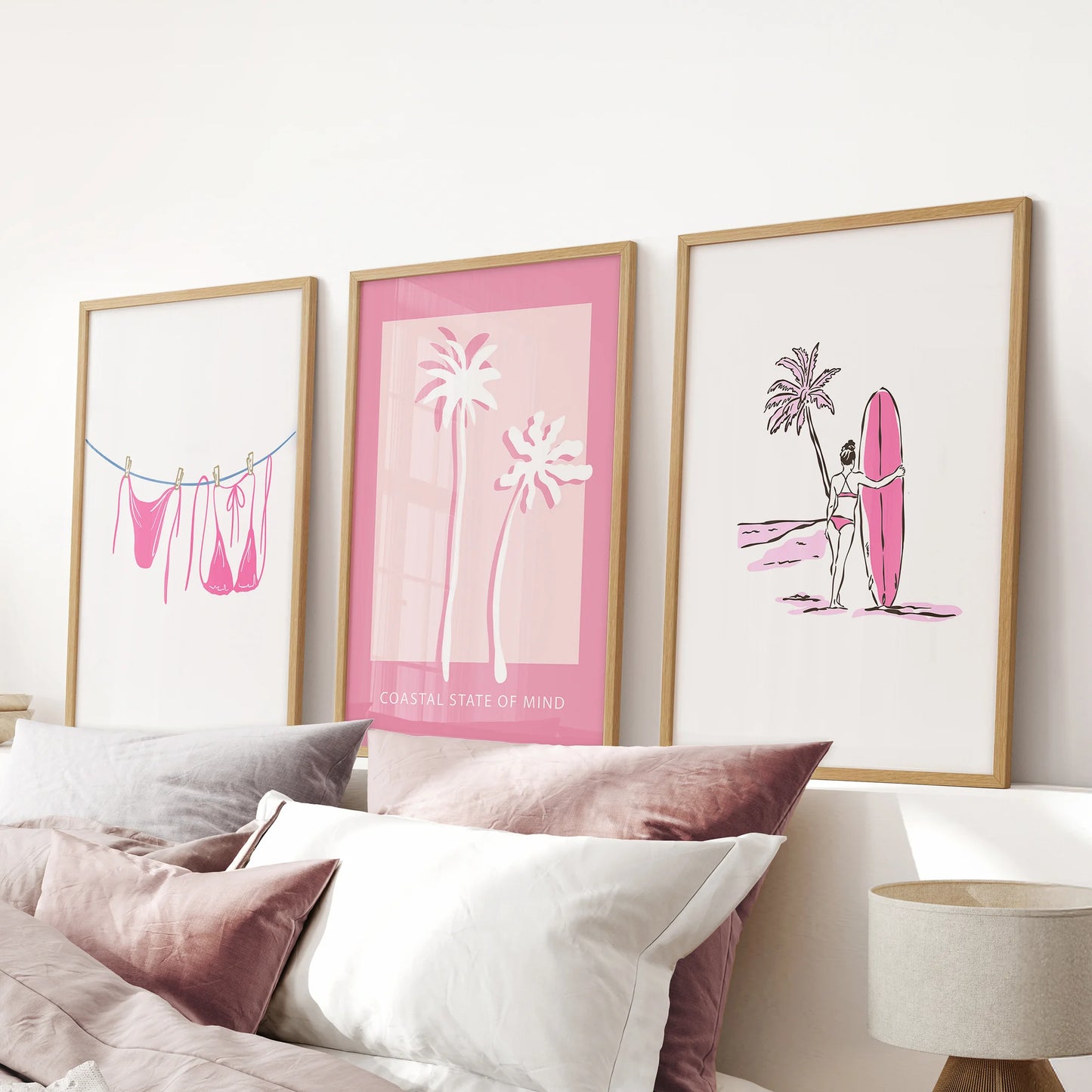 Light pink swimsuits three piece artwork with a light oak frame softens a pink bedroom, aligned over the bed headboard as relaxed beach wall art.