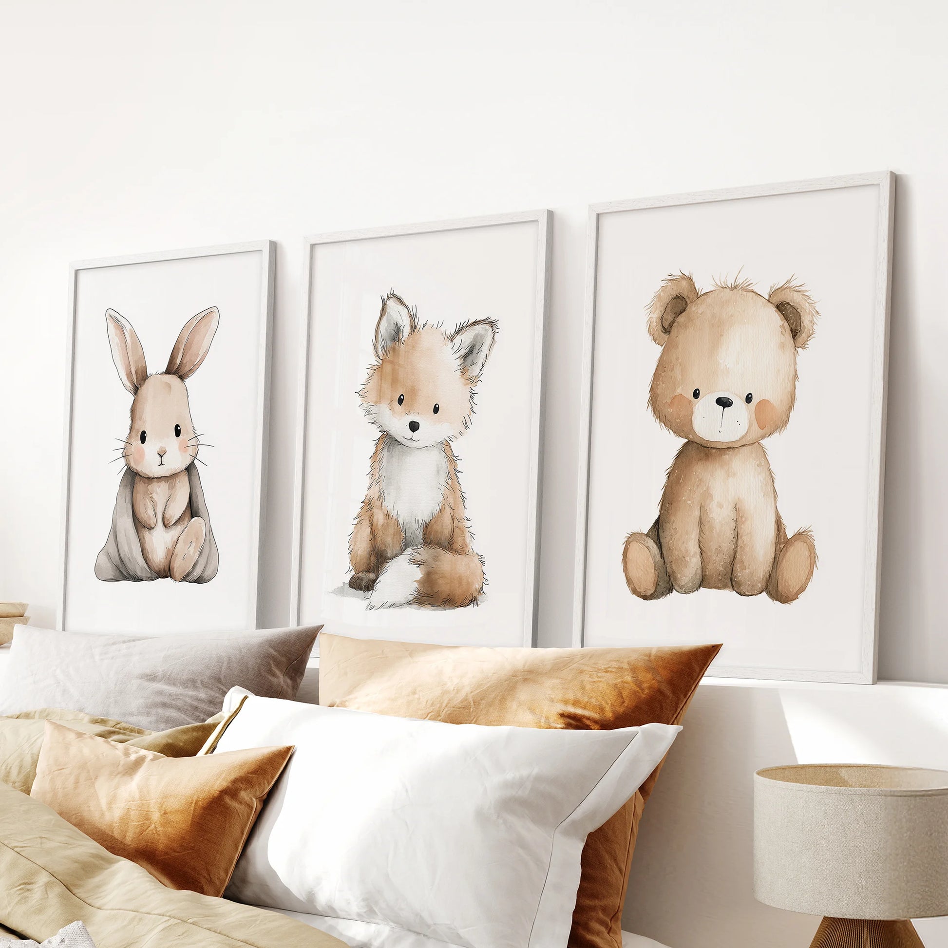 Bunny, fox and bear illustrations 3-piece art set lends a calm touch to the bedroom, with white frames aligned above the headboard.