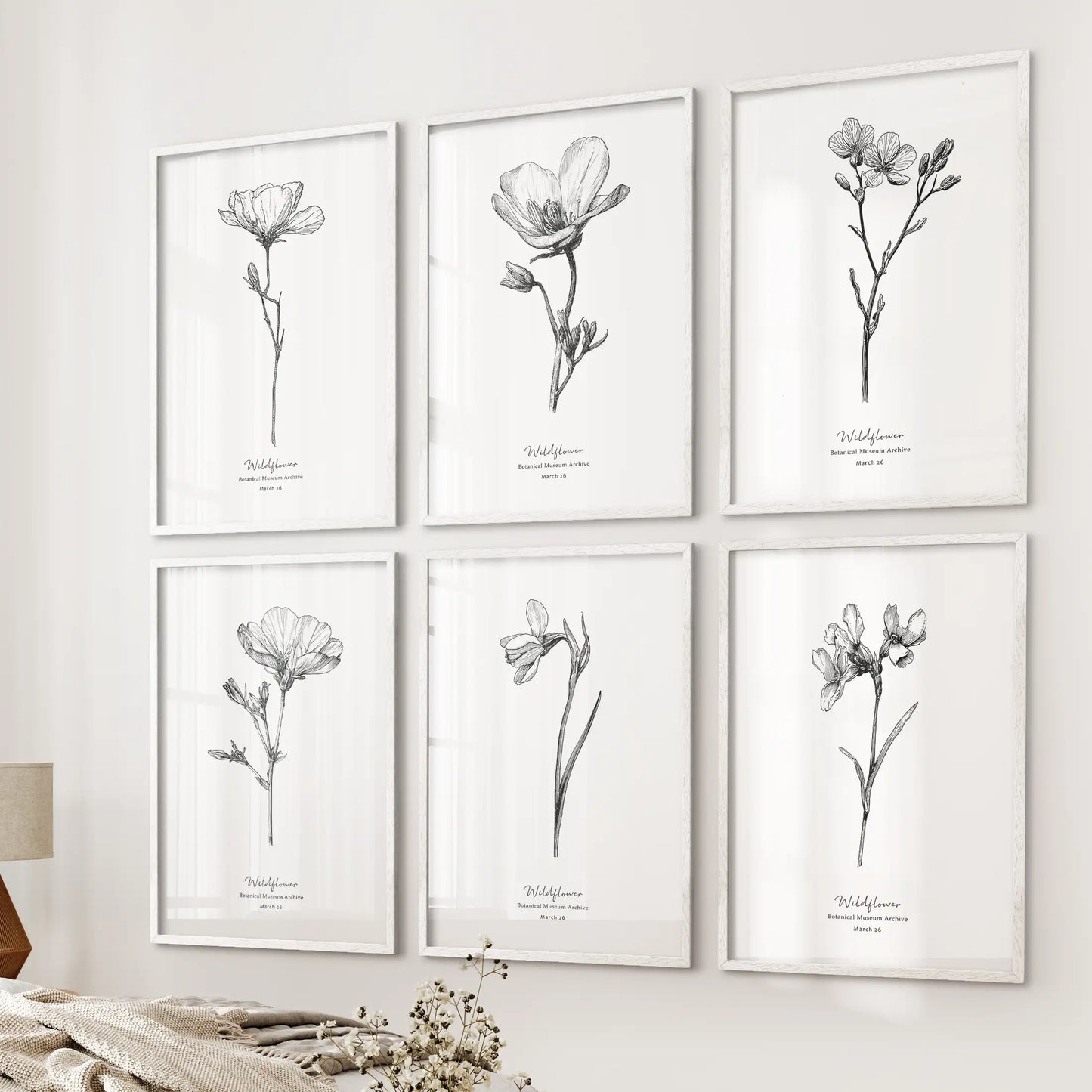 This six-piece wall art set of vintage botanical sketches in white frames lines the wall by the bed, adding a delicate and airy touch.