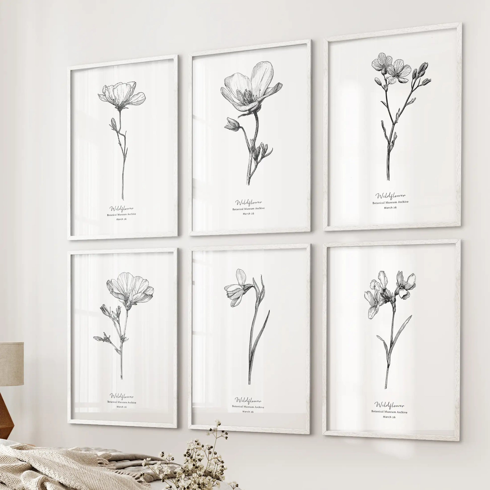 This six-piece wall art set of vintage botanical sketches in white frames lines the wall by the bed, adding a delicate and airy touch.