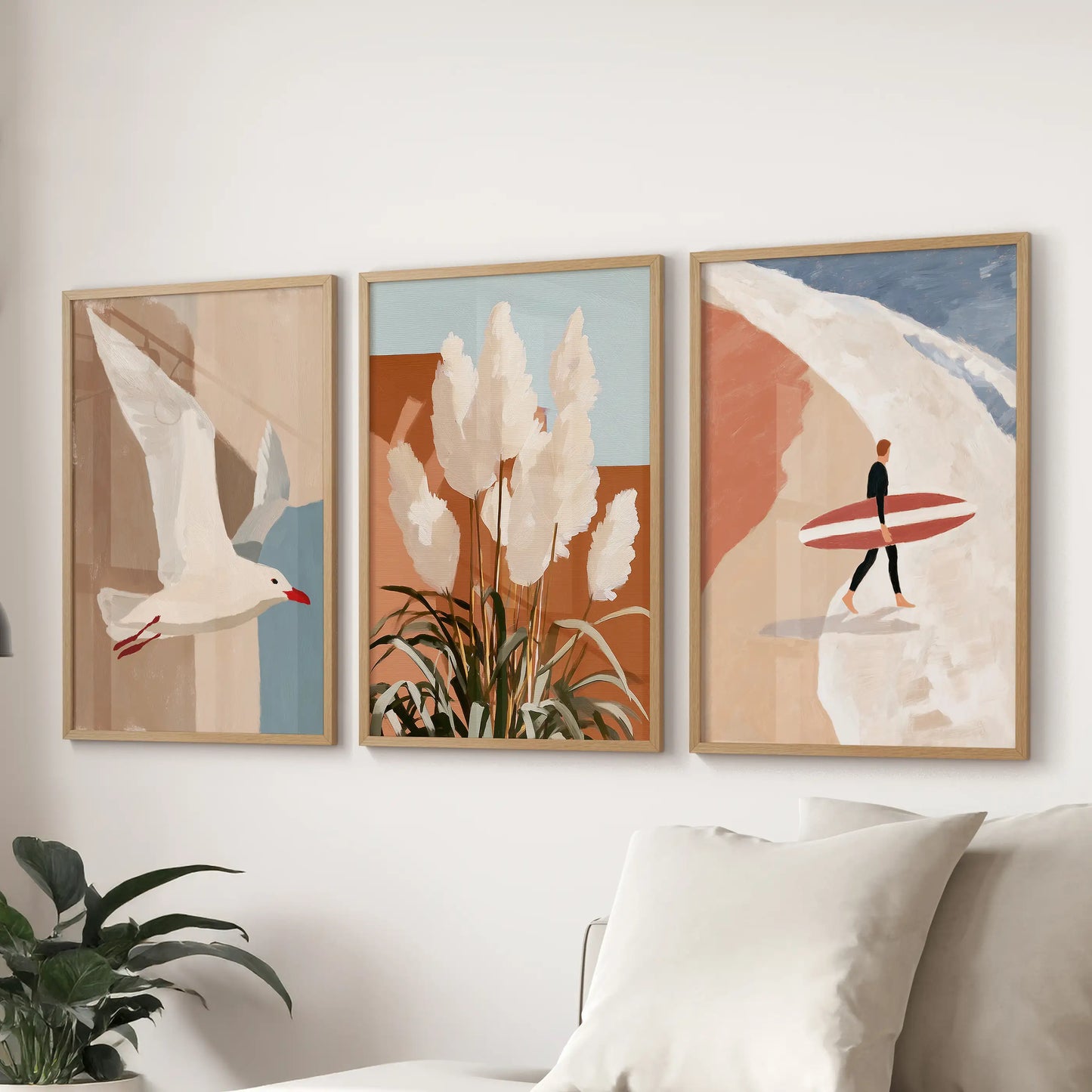Three solid-oak-framed pictures of pampas grass by the dunes hang above the couch, softening the sitting room with sunlit coastal texture.