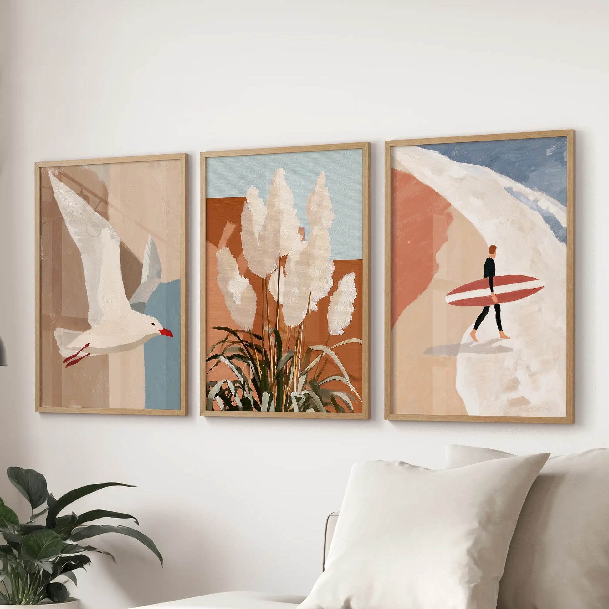 Three solid-oak-framed pictures of pampas grass by the dunes hang above the couch, softening the sitting room with sunlit coastal texture.