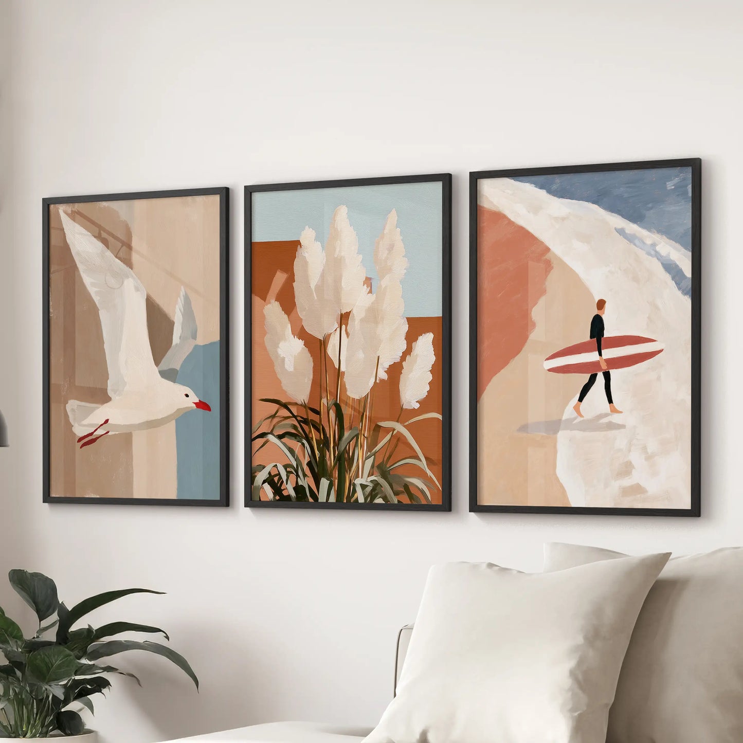 Three black-framed beach art prints in terracotta tones span the wall above the sectional, warming the family room with relaxed modern coastal ease.