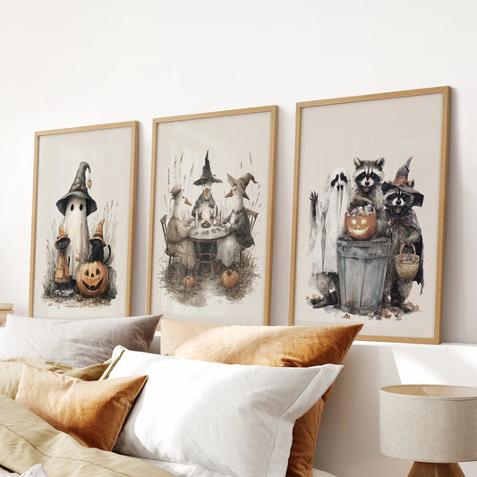 Little ghost character prints, a bedroom trio in natural wood frames, arranged above the bed headboard for soft Halloween whimsy.