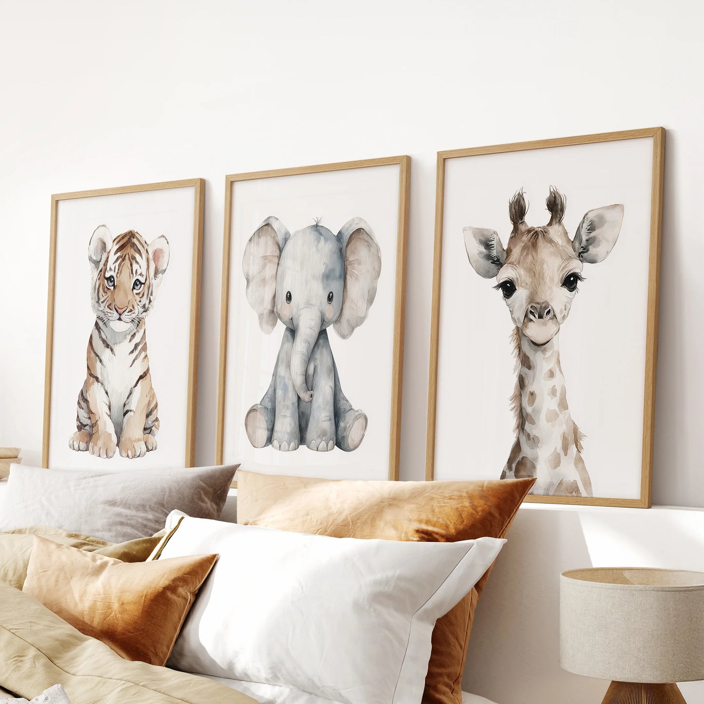 Gender-neutral nursery art trio with watercolor safari portraits. Thinwood frames above the bed.