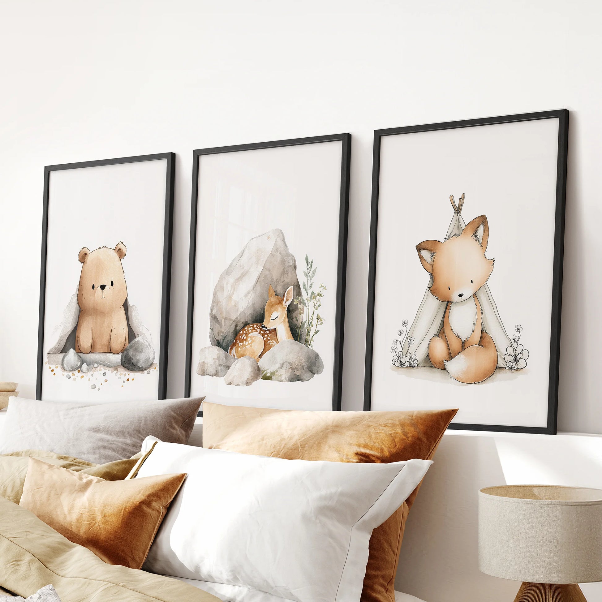 Forest creatures wall prints in a 3-print framed set lend a calm, unified look above the headboard in a bedroom, with sleek black frames.
