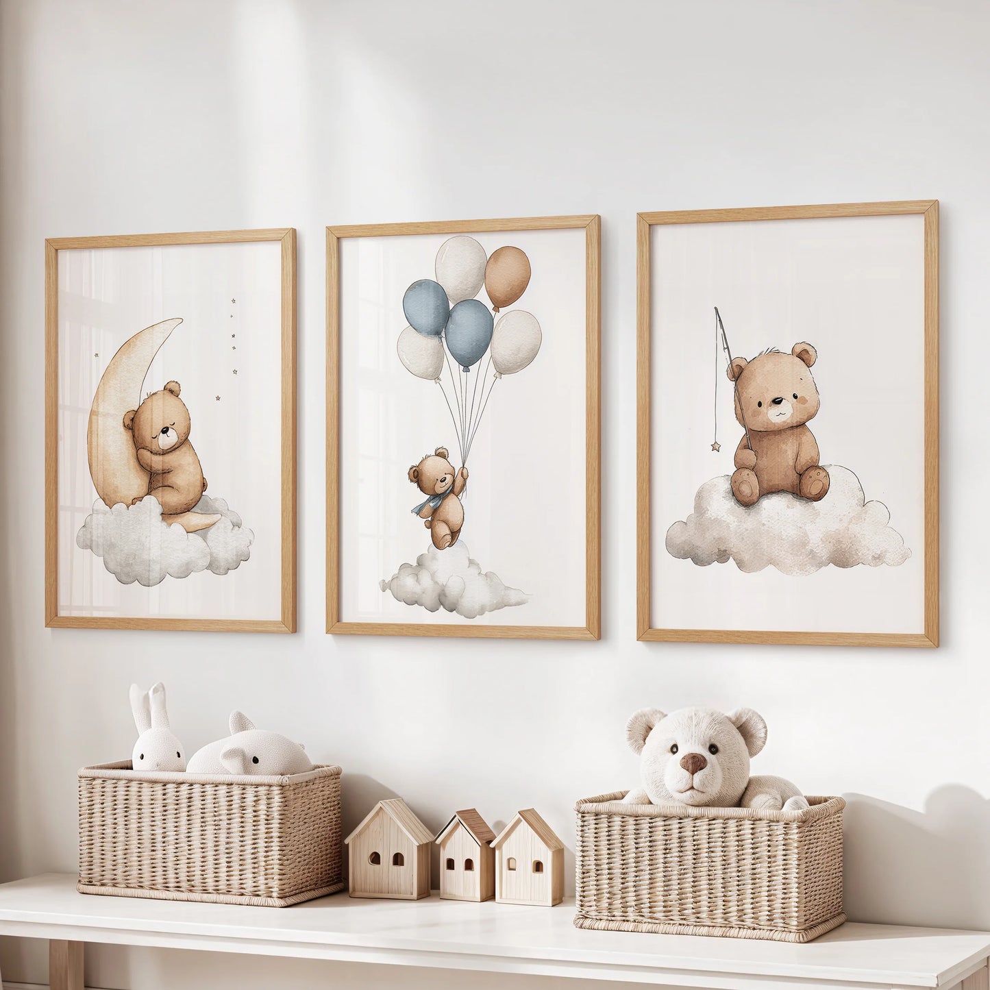 Three light-wood framed nursery prints of teddy bears on clouds—moon, balloons, and star—above a dresser with wicker baskets.