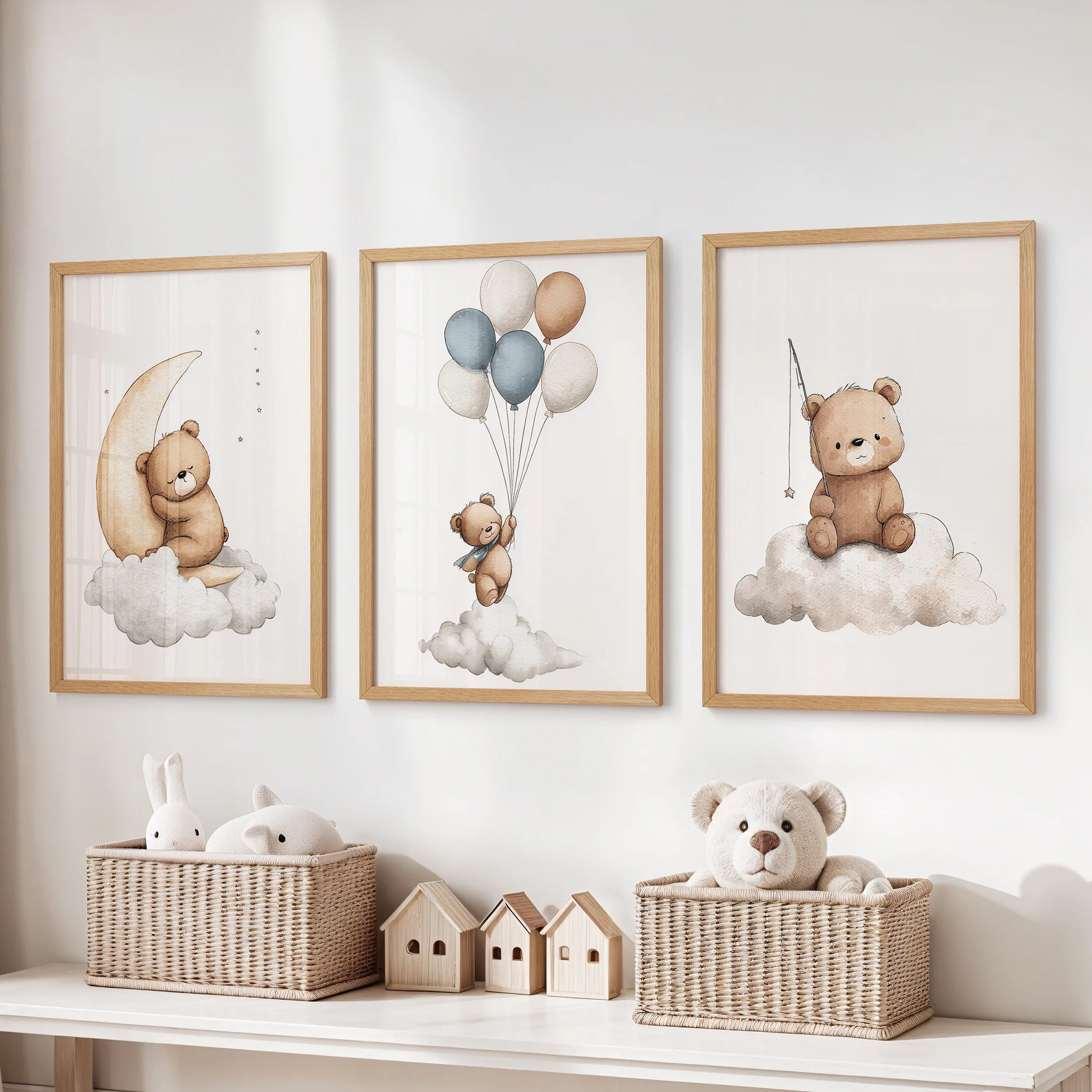 Three light-wood framed nursery prints of teddy bears on clouds—moon, balloons, and star—above a dresser with wicker baskets.