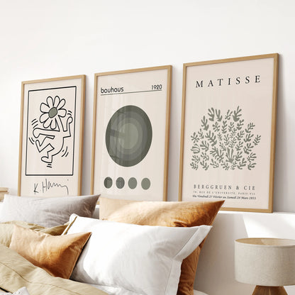 Green art posters, 3-piece artwork set, in warm oak frames and positioned over the headboard to bring Bauhaus lines to a relaxed bedroom.