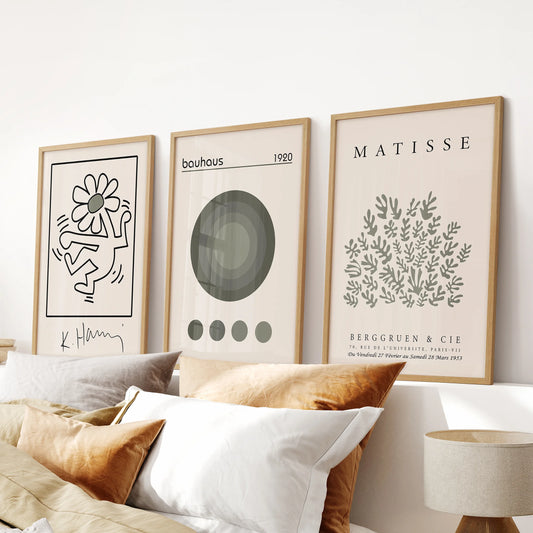 Green art posters, 3-piece artwork set, in warm oak frames and positioned over the headboard to bring Bauhaus lines to a relaxed bedroom.