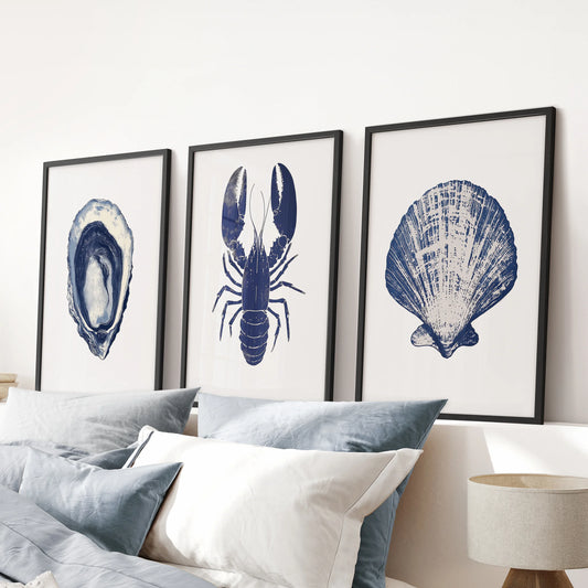 A 3-piece lobster and oyster wall art set in black frames brightens the pink bedroom above the headboard with a polished beach-house feel.