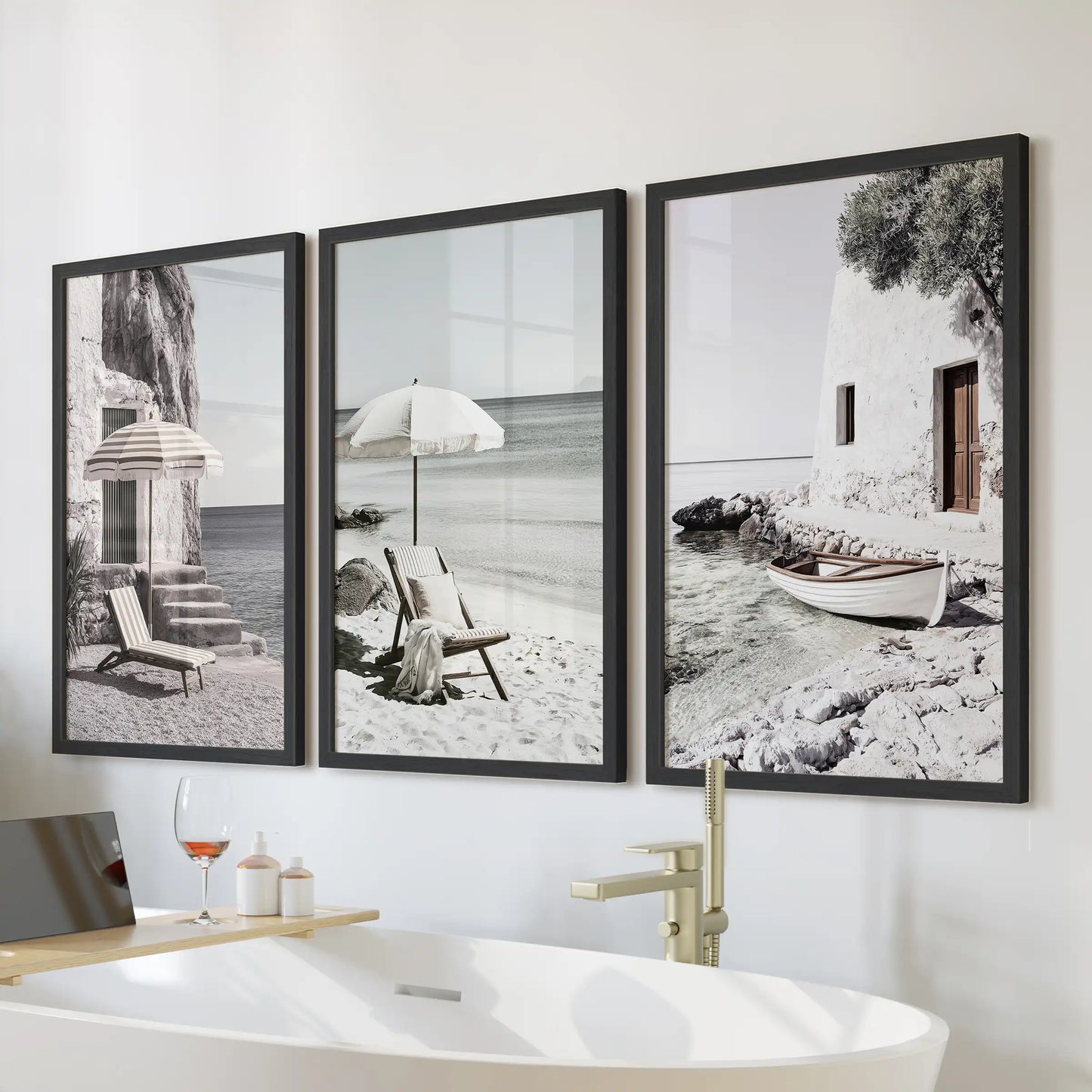 A 3-print wall art bundle shows beach umbrellas on a Greek shore in slim black frames. Displayed above the bath, it adds a calm coastal feel to the bathroom.