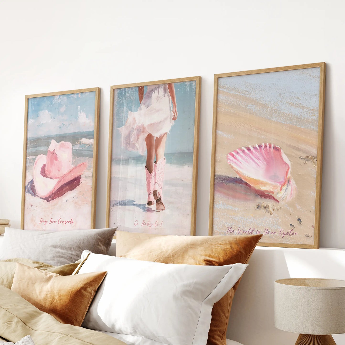 Western boots artwork trio of wall art in light oak frames spans the bedroom over the headboard, adding rosy desert notes to a breezy coastal palette.