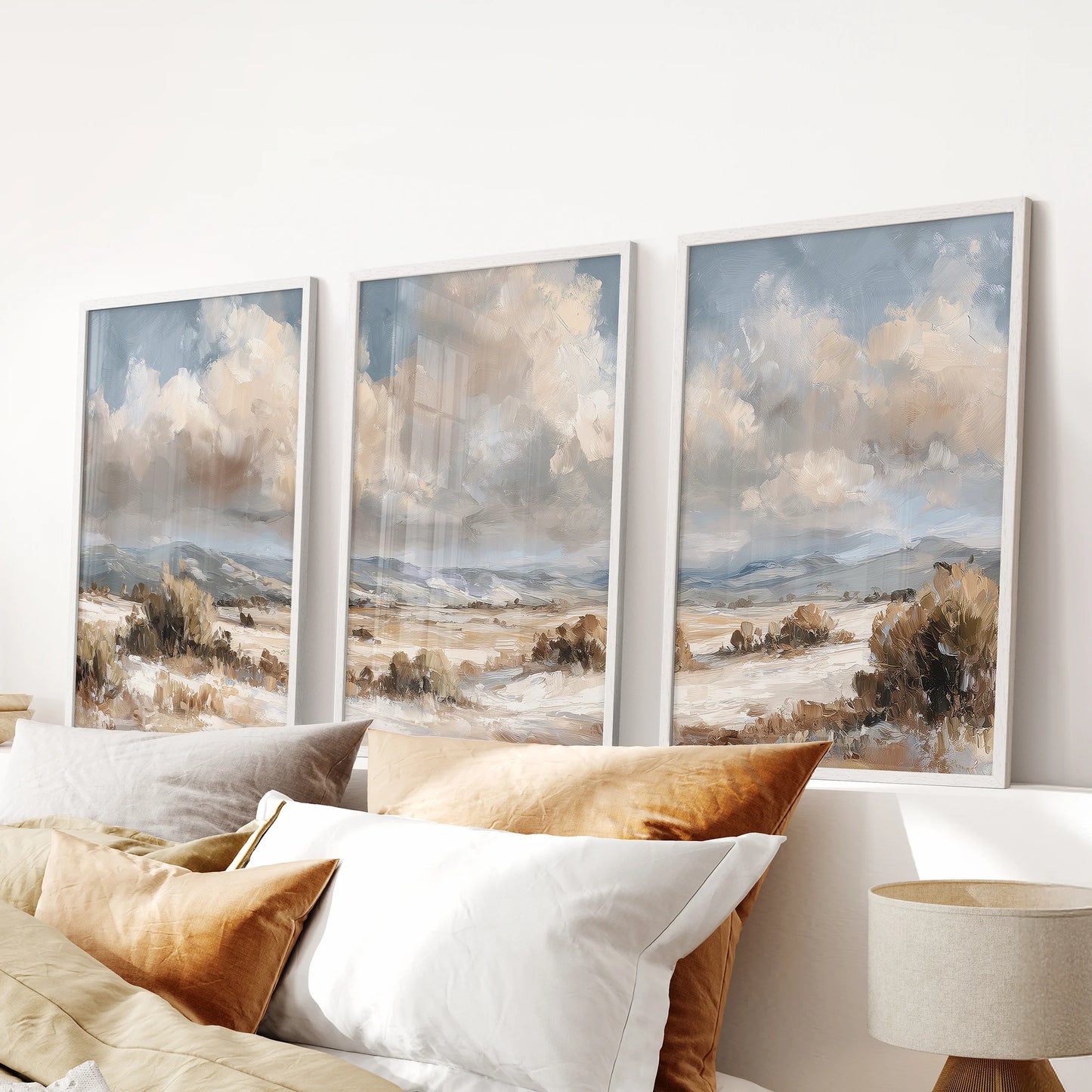 Coastal seascapes, a poster trio in white-framed, lend airy neutral wall art to the bedroom, lined up neatly above the headboard.