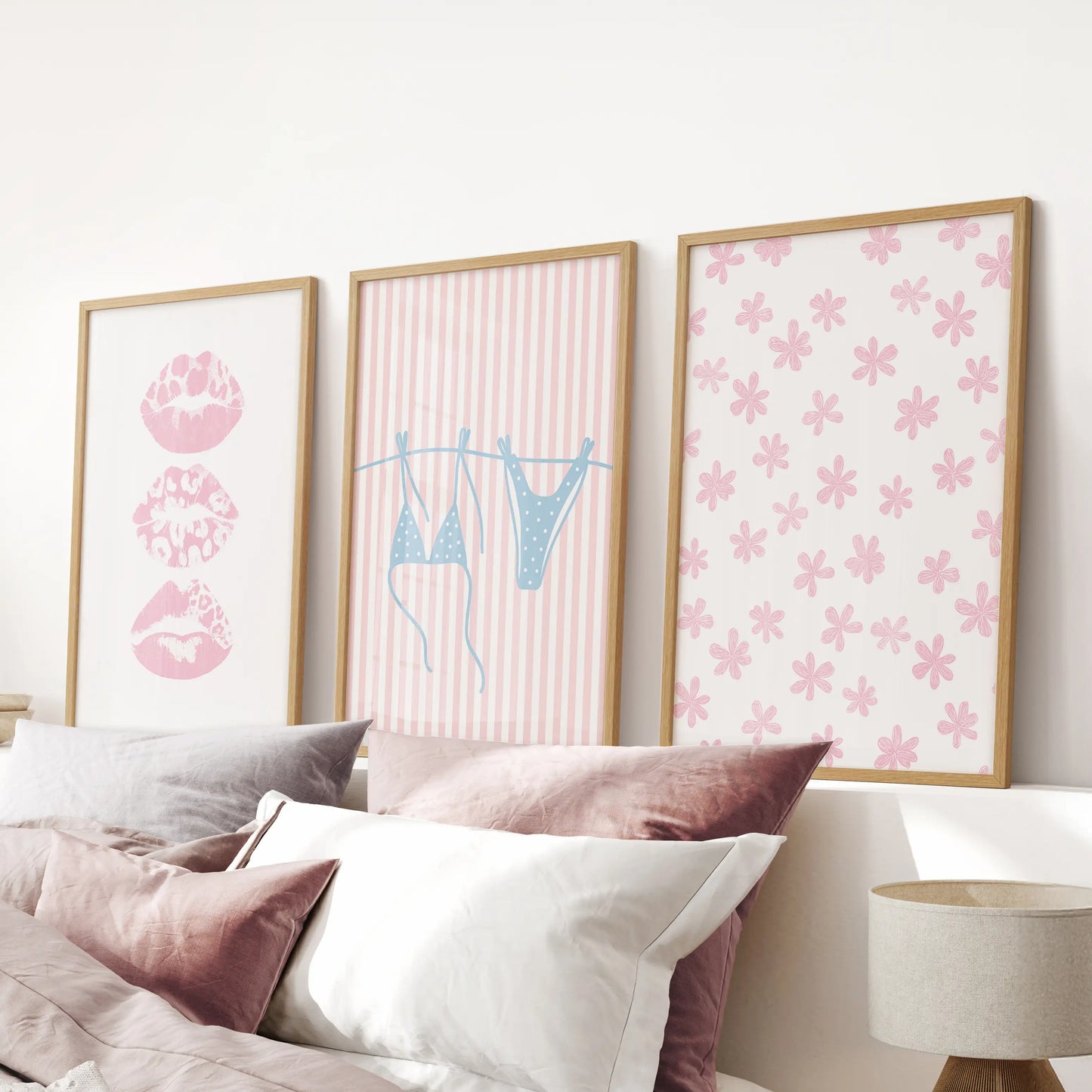 A 3-piece seaside print set in light wood frames crowns the bed’s headboard, blending soft beach notes into the pink bedroom.