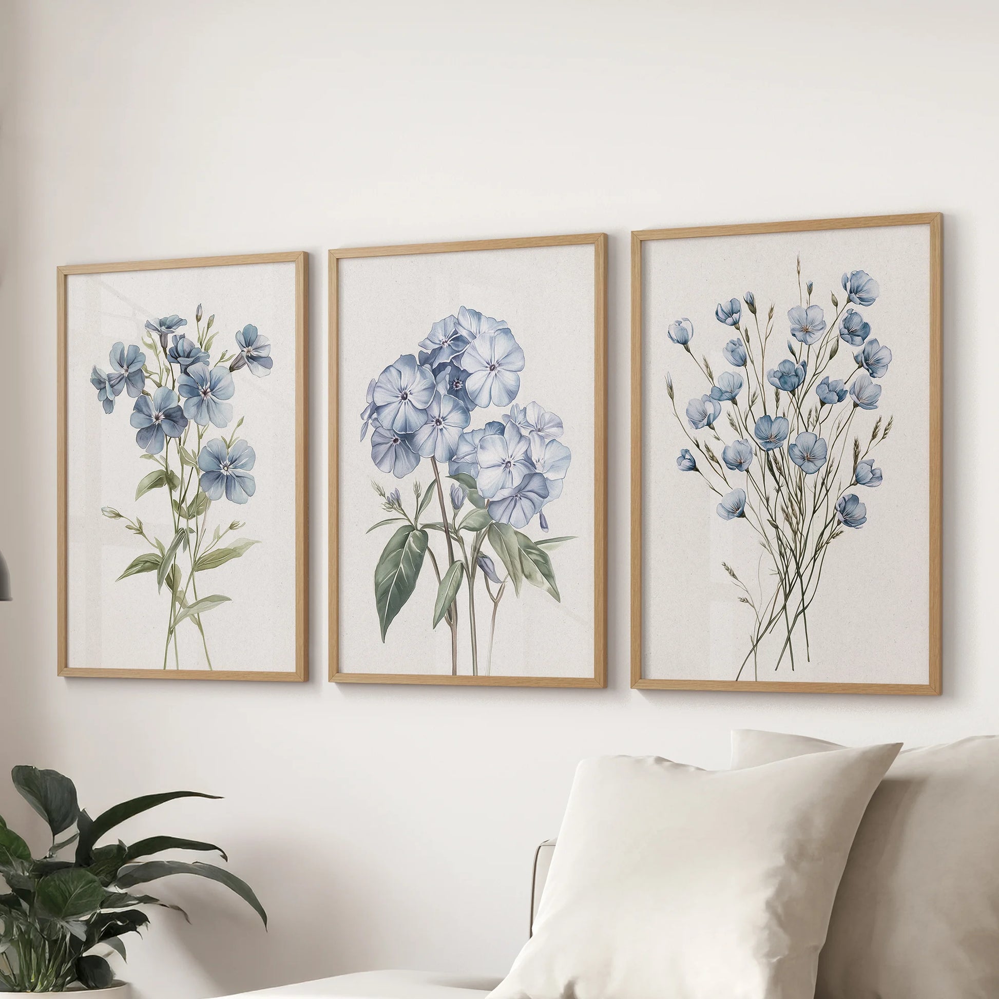 Blue hydrangea watercolor prints, a gallery set of three in wooden frames, anchor the wall over the sectional sofa to refresh the lounge.