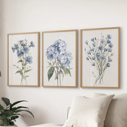 Blue hydrangea watercolor prints, a gallery set of three in wooden frames, anchor the wall over the sectional sofa to refresh the lounge.