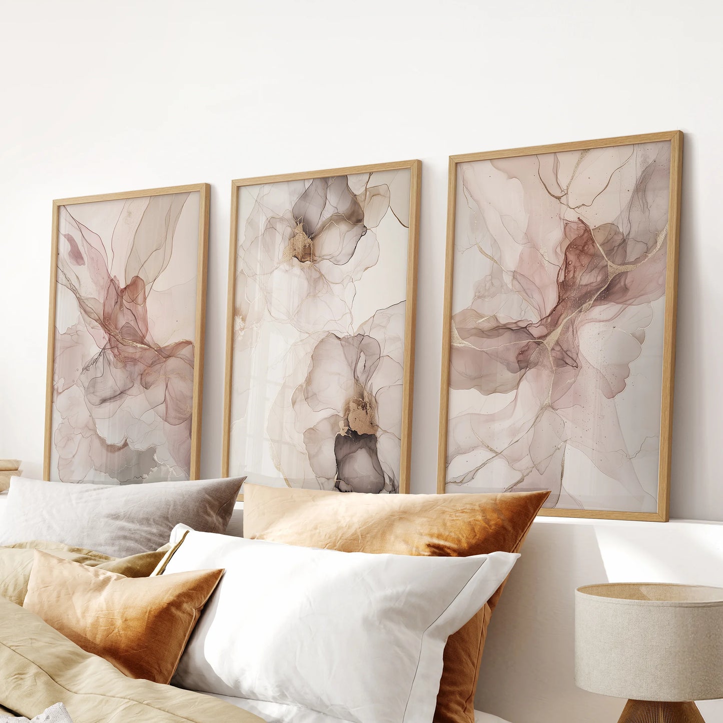 Blush watercolor floral abstract prints, three-print set, in natural wood frames to brighten a bedroom wall above the bed with gentle, airy color.