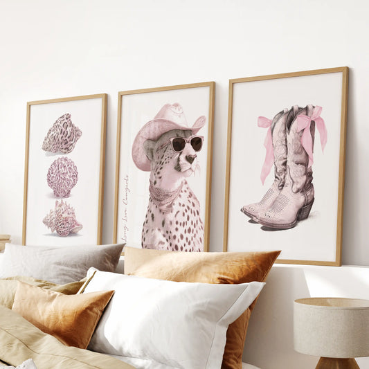 Long Live Cowgirls set of three prints in slim wood frames styles a bedroom over the headboard, delivering bold type and pink notes with polish.