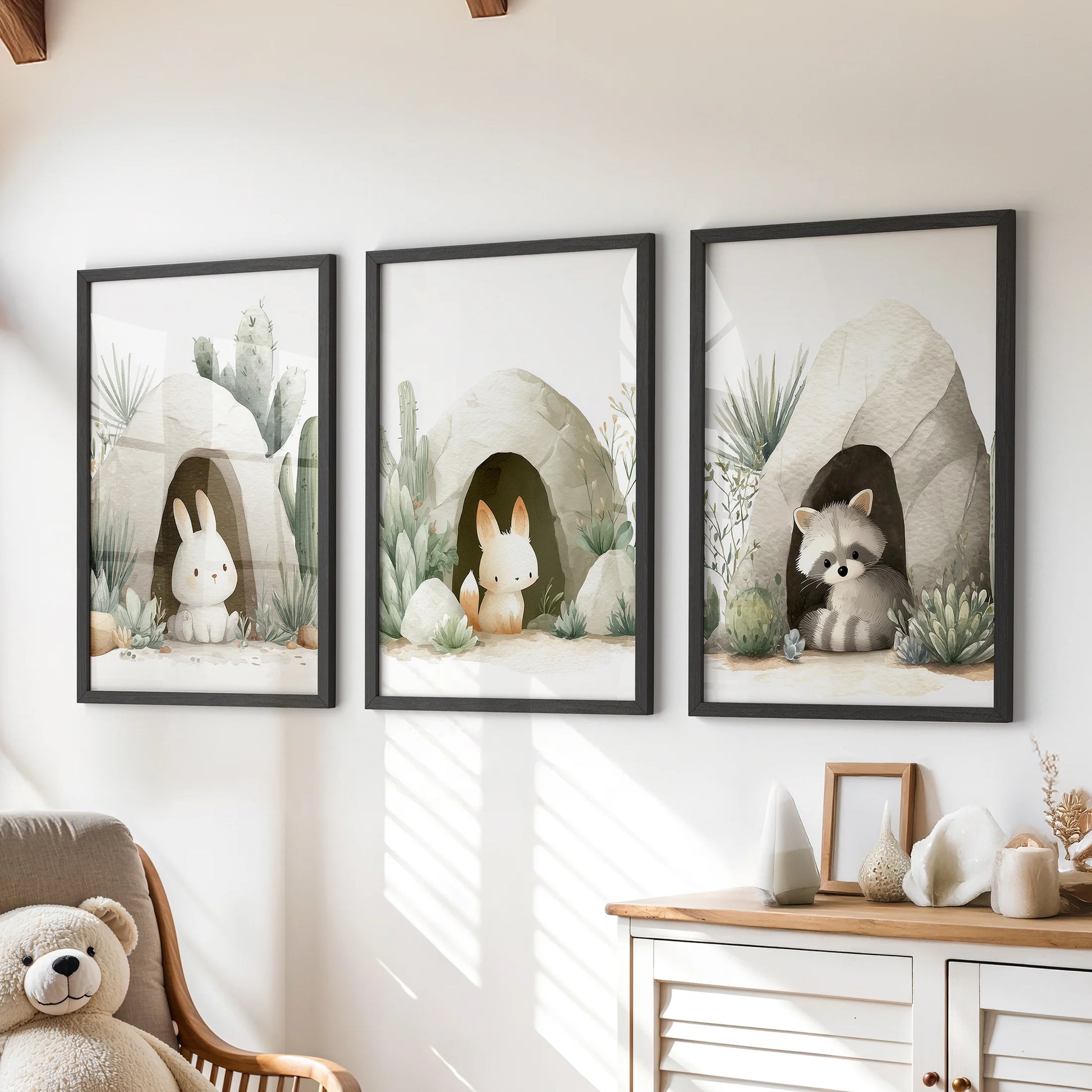 Woodland animal prints over nursery dresser—two bunnies and a raccoon among cactus and succulents.