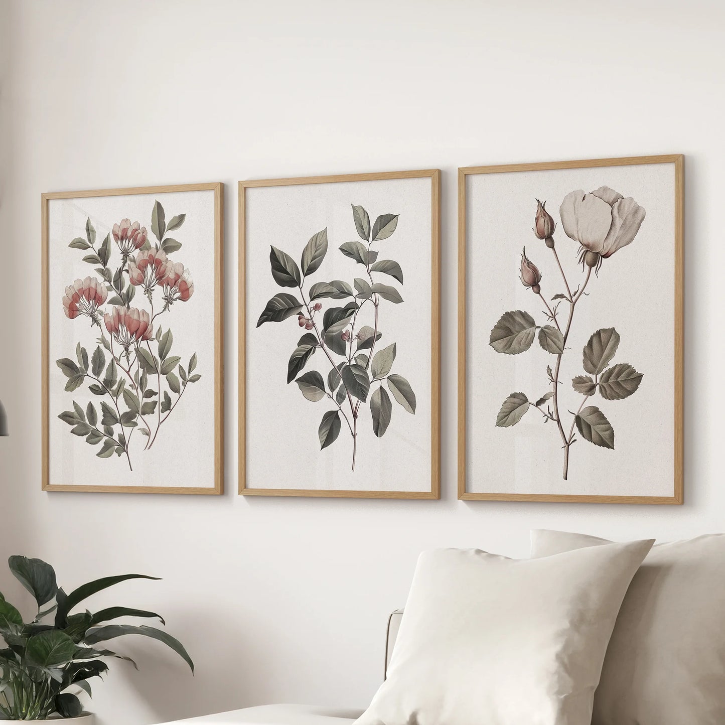 Classic floral art prints, a set of three framed pieces, hang over the living room sectional in warm oak frames to elevate the space with vintage softness.