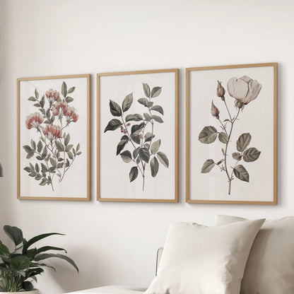 Classic floral art prints, a set of three framed pieces, hang over the living room sectional in warm oak frames to elevate the space with vintage softness.
