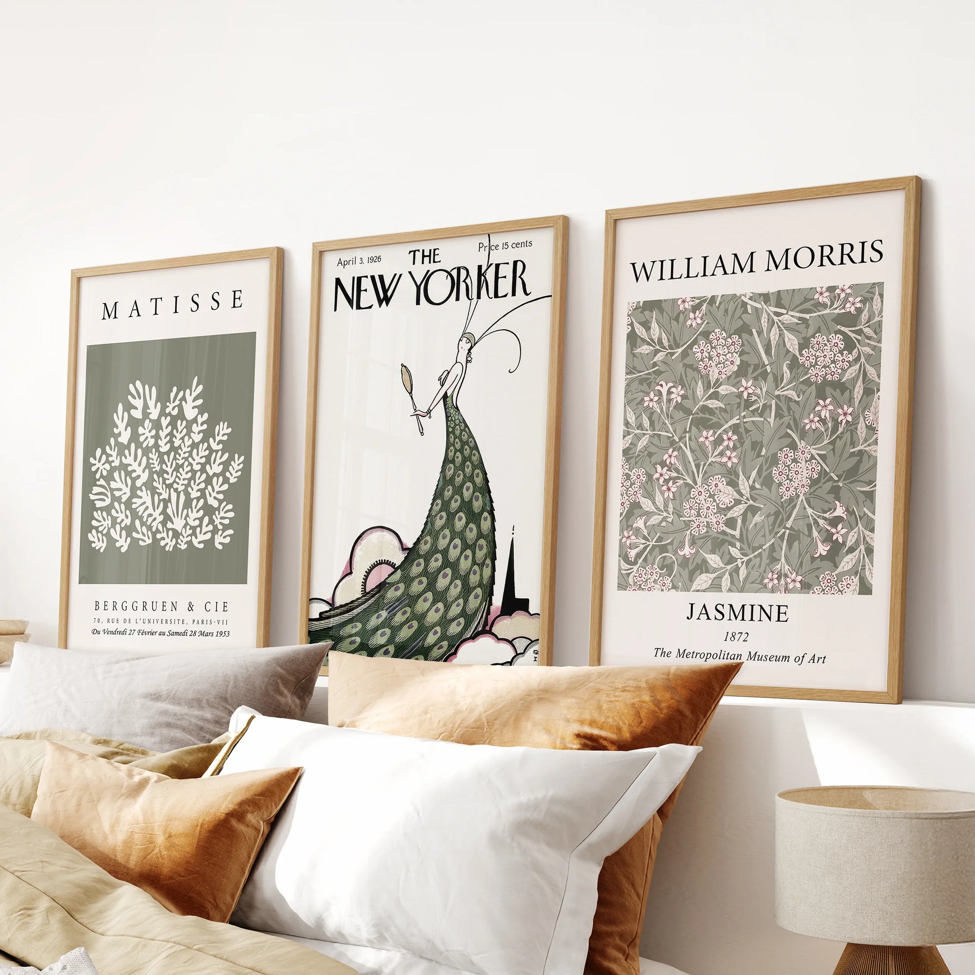 Three-piece magazine cover art sets in natural oak frames add retro warmth to a bedroom wall above the bed headboard.