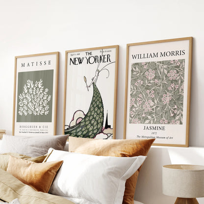 Three-piece magazine cover art sets in natural oak frames add retro warmth to a bedroom wall above the bed headboard.