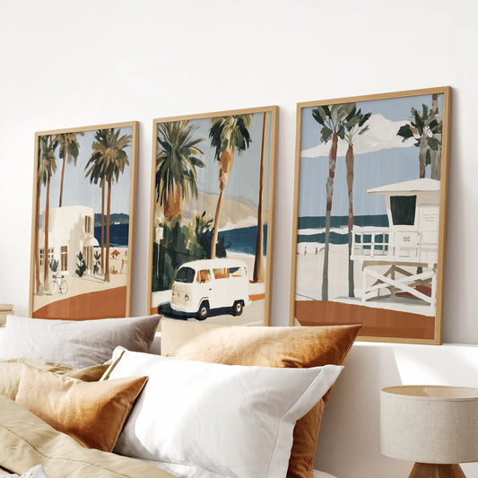 Surfers and waves wall art, a set of three pictures in light wood frames, finishes a bedroom display over the bed with relaxed, sunlit motion.
