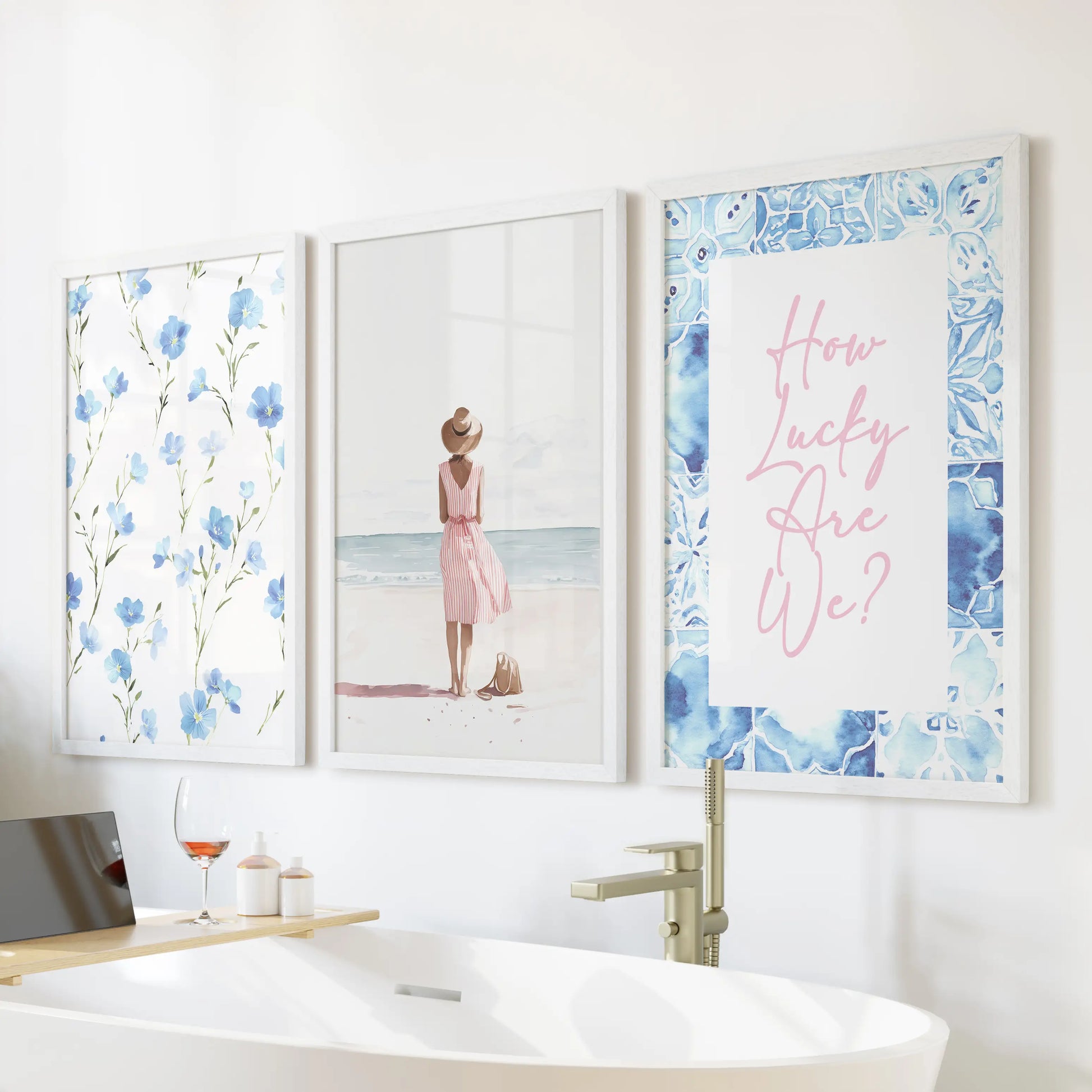 Crisp white frames hold a trio of granddaughter-inspired wall prints positioned above the tub wall, adding a gentle coastal charm to the bathroom.