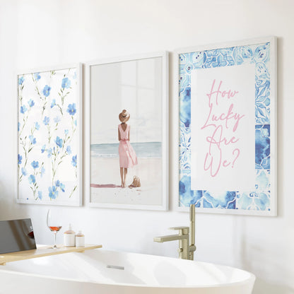 Crisp white frames hold a trio of granddaughter-inspired wall prints positioned above the tub wall, adding a gentle coastal charm to the bathroom.