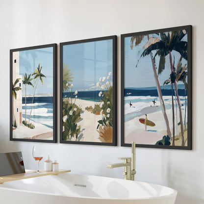 Three black-framed palm tree prints form breezy coastal wall art above the freestanding bathroom tub, giving the space an open, seaside calm.
