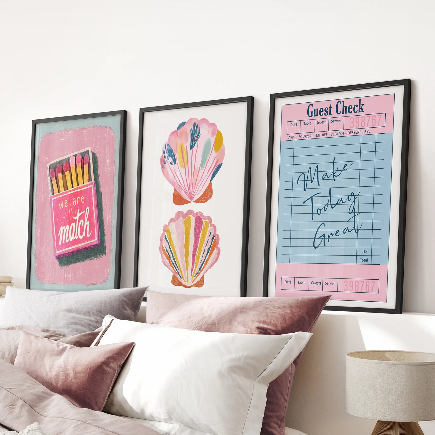Matchbox-style graphic poster trio brings punchy wall art to the pink bedroom, hung above the bed in black-framed prints for a cheeky coastal vibe.