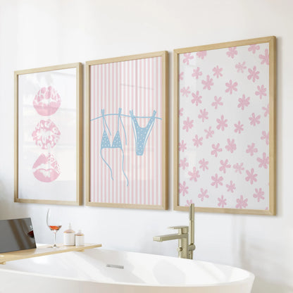 A 3-piece coastal art set with light blue bikini imagery in natural wood frames adds playful charm above the freestanding tub.