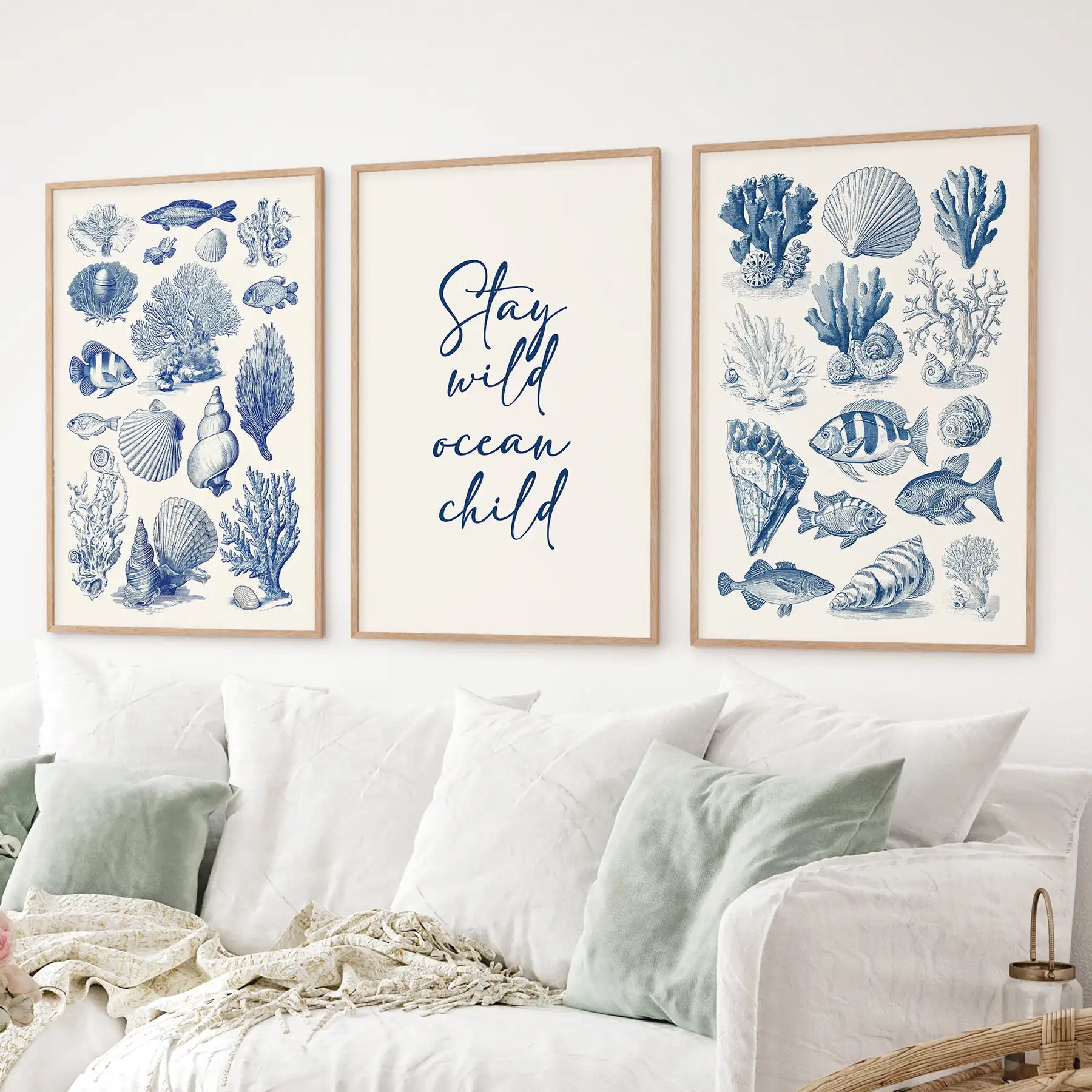 Set of 3 coastal wall art prints with blue sea life illustrations and 'Stay wild ocean child' quote. Thinwood frames over the couch.